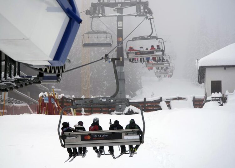 Skiers ride the lift line on Mount Kopaonik, Serbia, Thursday, Dec. 9, 2021. As most of Europe reintroduces measures to help curb the spread of the omicron variant, Bosnia, to the delight of its winter tourism industry, still maintains a relatively laissez-fair approach to the soaring COVID-19 infection numbers across the continent.