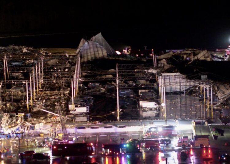 Delivery vehicles with the Amazon Prime logo sit parked at a damaged Amazon.com, Inc warehouse as emergency crews respond after a tornado passed through Edwardsville, Illinois, US, December 10, 2021 in this still image taken from drone video obtained on December 11, 2021.