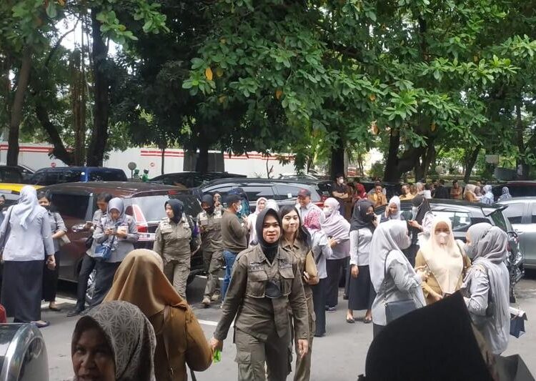 People wait outside after evacuating a government building following an earthquake in Makassar, South Sulawesi, Indonesia, Tuesday, Dec. 14, 2021