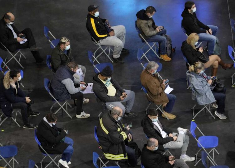 People wait after they received Covid-19 vaccine at the National Velodrome in Saint-Quentin-en-Yvelines, west of Paris on Dec. 17, 2021.