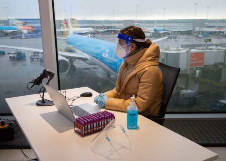 A worker waits for arriving international passengers to register them for Covid-19 testing at Schiphol Airport, in the Netherlands, on Dec 2, 2021.