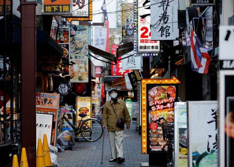 A man wearing a protective mask making his way at a restaurant district in Tokyo, Japan.