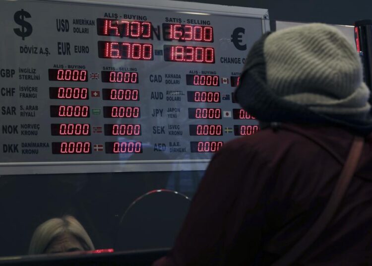 A woman changes Turkish lira for USD at a currency exchange shop, in Ankara, Turkey, on December 16, 2021.