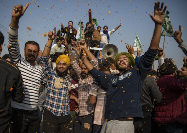 Indian farmers end yearlong protests and return home 1 - Egyptian Gazette Indian farmers are showered with flower petals as they dance while leaving the protest site in Singhu, on the outskirts of New Delhi, India, Saturday. Tens of thousands of jubilant Indian farmers on Saturday cleared protest sites on the capital’s outskirts and began returning home, marking an end to their year-long demonstrations against agricultural reforms that were repealed by Prime Minister Narendra Modi's government in a rare retreat.