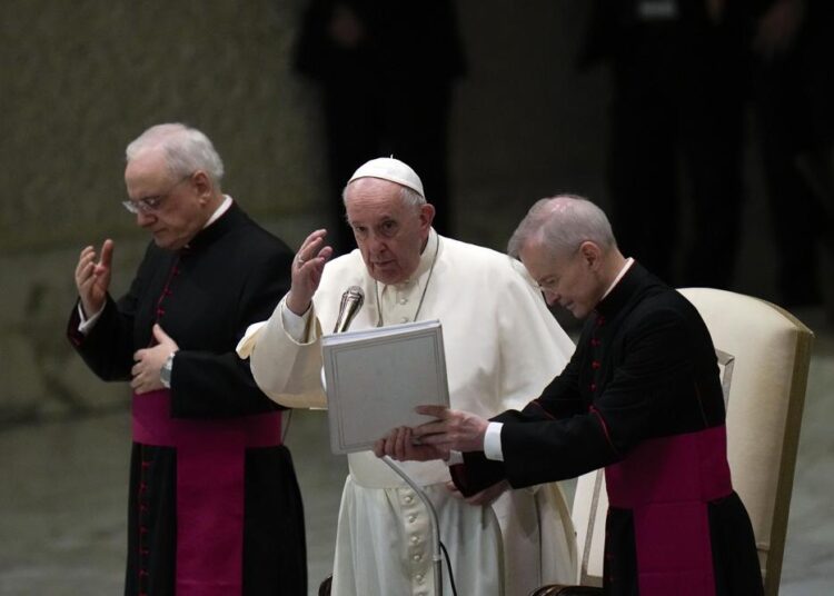 Pope Francis delivers his blessing at the end of his weekly general audience in the Paul VI Hall, at the Vatican, Wednesday, Dec. 22, 2021.