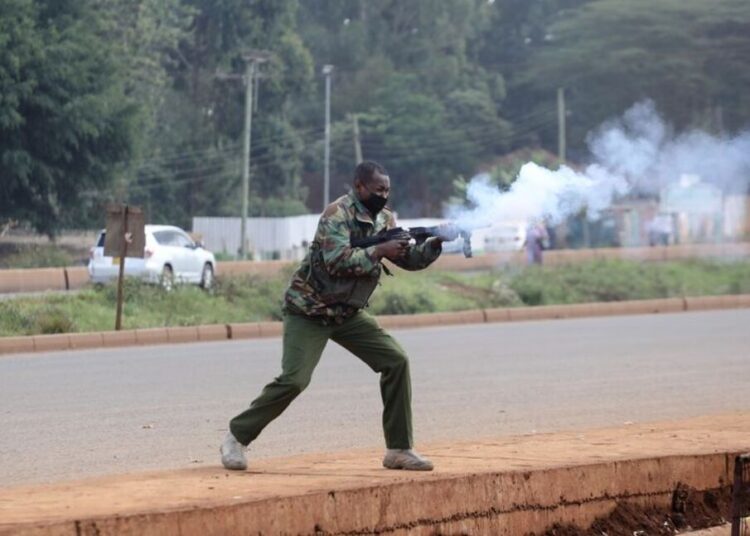 A police officers fires tear gas at protesters during clashes that erupted after a Kenyan police officer shot dead several people and himself in a rampage attack in Nairobi, Kenya, December 7, 2021.