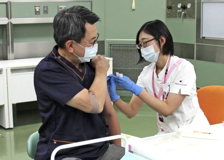 A doctor receives a Covid-19 booster shot at Chiba University Hospital in Chiba, Japan.