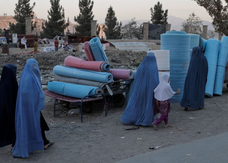 Women wearing burqas walk in a second-hand market where people sell their home appliances and other belongings, in Kabul, Afghanistan October 9, 2021.