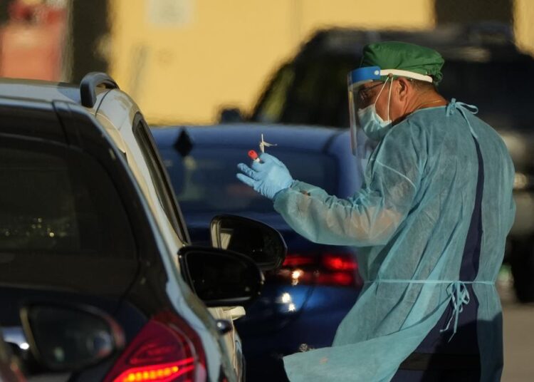 New Covid-19 cases in US soar to highest levels on record 1 - Egyptian Gazette A healthcare worker tests people for COVID-19 at a drive-up testing center at Tropical Park, yesterday.