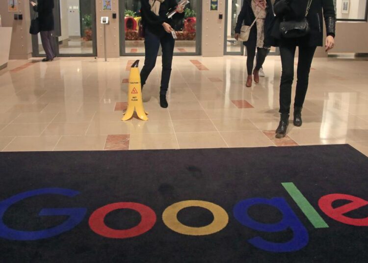 FILE - In this file photo dated Nov. 18, 2019, Google employees walks out of Google France building in Paris. France. French regulators on Thursday fined Google and Facebook a total of more than 200 million euros ($226 million) for not making it as easy for users to opt out of tracking as it is for them to accept it.