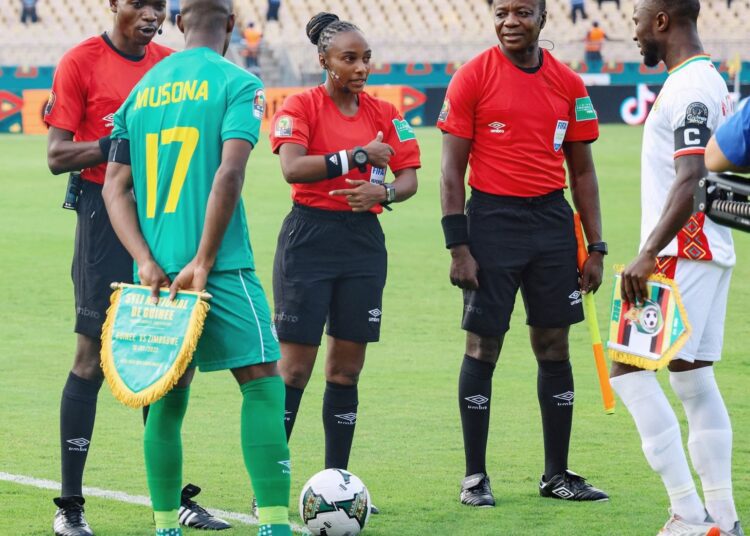 History-making Rwandan referee Salima Mukansanga (C) and the captains of Zimbabwe and Guinea, Knowledge Musona (1stL) and Naby Keita (1stR) before an AFCON Group B match in Yaounde on January 18, 2022.
