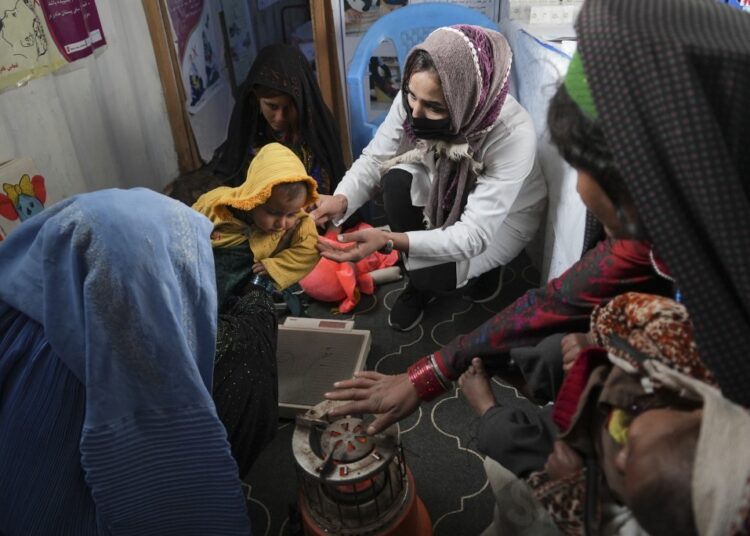UN chief warns millions of Afghans are on 'verge of death' 1 - Egyptian Gazette A nurse checks the weight of a child in a makeshift clinic organized by World Vision at a settlement near Herat, Afghanistan, Dec. 16, 2021.