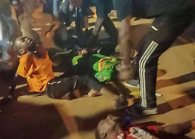 People assist victims of a stampede outside a stadium hosting an African Cup of Nations soccer game in Yaounde, Cameroon, Monday Jan. 24, 2022. Several people have died in a stampede that happened as crowds struggled to get access to Olembe Stadium to watch the host country play Comoros in a last 16 knockout game in Africa's top soccer tournament.