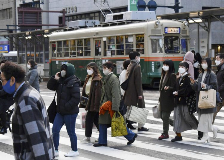 People wearing face masks cross a street in Hiroshima, western Japan on Jan. 6, 2022. Japan approved new restrictions on Friday to curb a sharp rise in coronavirus cases in the three most affected southwestern regions of Okinawa, Yamaguchi and Hiroshima.