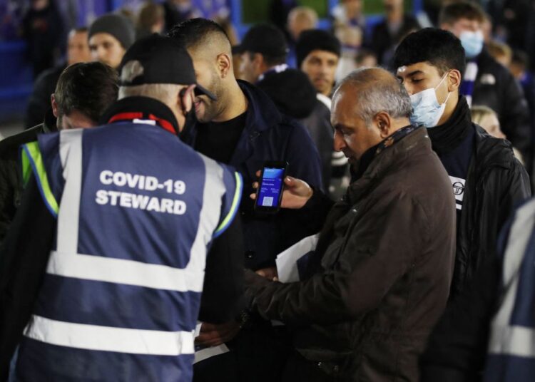 Premier League reports fall in Covid-19 cases 1 - Egyptian Gazette Fans get their coronavirus passes checked outside the stadium before the match between Chelsea and Everton at Stamford Bridge, London December 16, 2021.