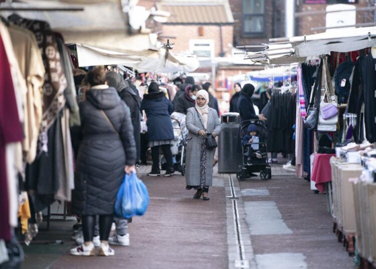People shop at Longsight Market in Manchester, England, Wednesday, Jan. 19, 2022. Consumer prices in the United Kingdom have risen at the fastest pace in almost 30 years as higher costs for energy, transportation, food and furniture squeezed household incomes.