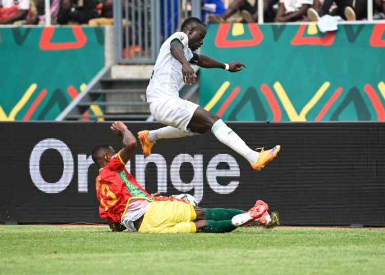 Guinea’s defender Issiaga Sylla (down) tackles Senegal’s forward Sadio Mane during the Group B AFCON 2021 match in Bafoussam, January 14, 2022.