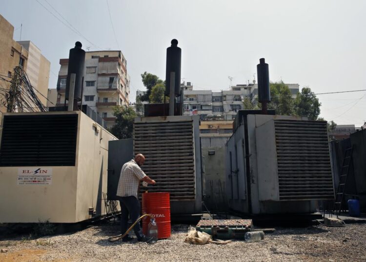 FILE - Mamdouh al-Amari refuels privately-owned diesel generators that provide power to homes and businesses, in the southern suburbs of Beirut, Lebanon, July 16, 2018. Internet services were disrupted in Lebanon Sunday, Jan. 16, 2022, because of diesel shortages, according to the state provider, adding another essential service to the list of casualties of the country’s snowballing economic crisis.