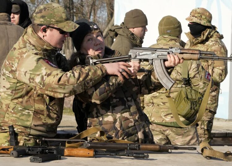 Flights to Ukraine halted, redirected as crisis brews 1 - Egyptian Gazette An instructor shows a woman how to use a Kalashnikov assault rifle, as members of a Ukrainian far-right group train, in Kyiv, Ukraine, Sunday. Russia denies it intends to invade but has massed well over 100,000 troops near the Ukrainian border and has sent troops to exercises in neighboring Belarus, encircling Ukraine on three sides. US officials say Russia's buildup of firepower has reached the point where it could invade on short notice.
