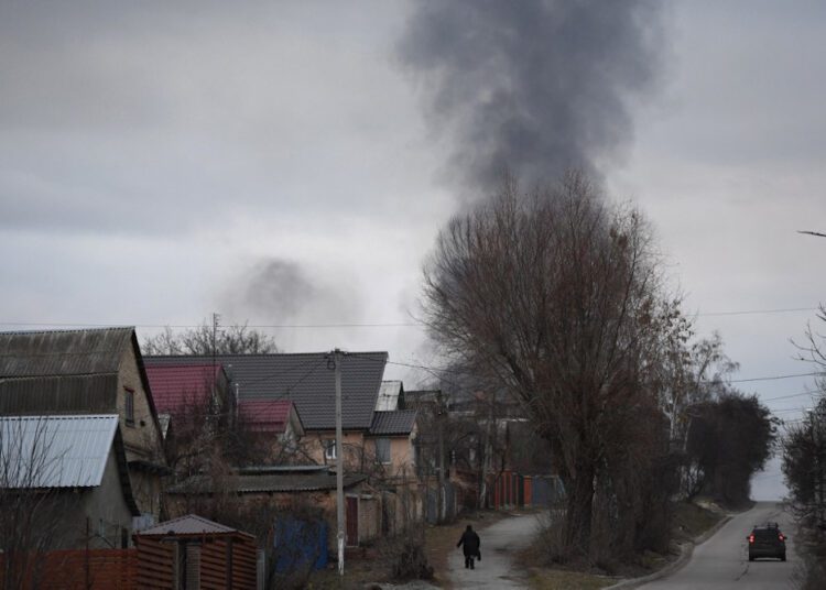 Russia says destroys over 70 military targets in Ukraine 1 - Egyptian Gazette A local resident walking in a street as smoke rises near the town of Hostomel and the Antonov Airport, in northwest Kyiv on Thursday.