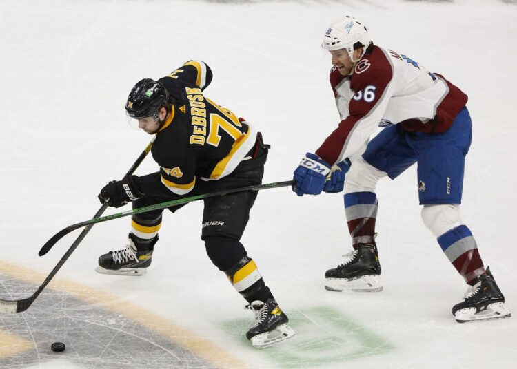 Colorado Avalanche's Kurtis MacDermid (R) tries to slow down Boston Bruins' Jake DeBrusk during the second period of an NHL hockey game in Boston.
