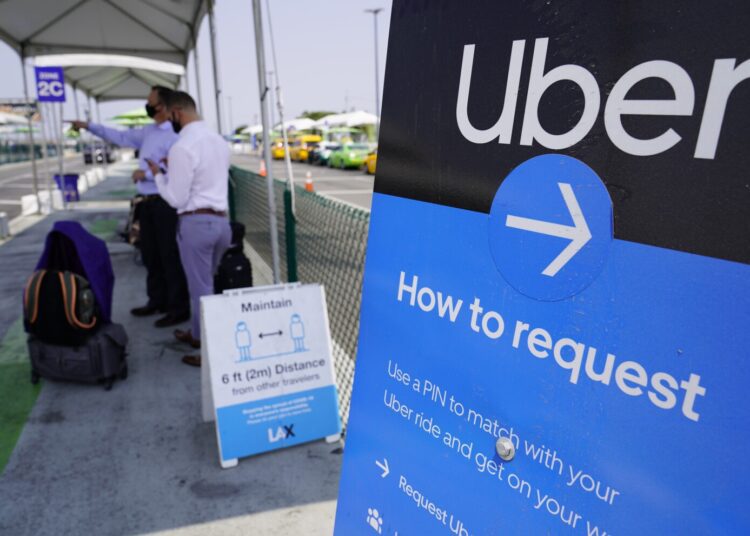 Travelers request an Uber ride at Los Angeles International Airport's LAX-it pick up terminal.