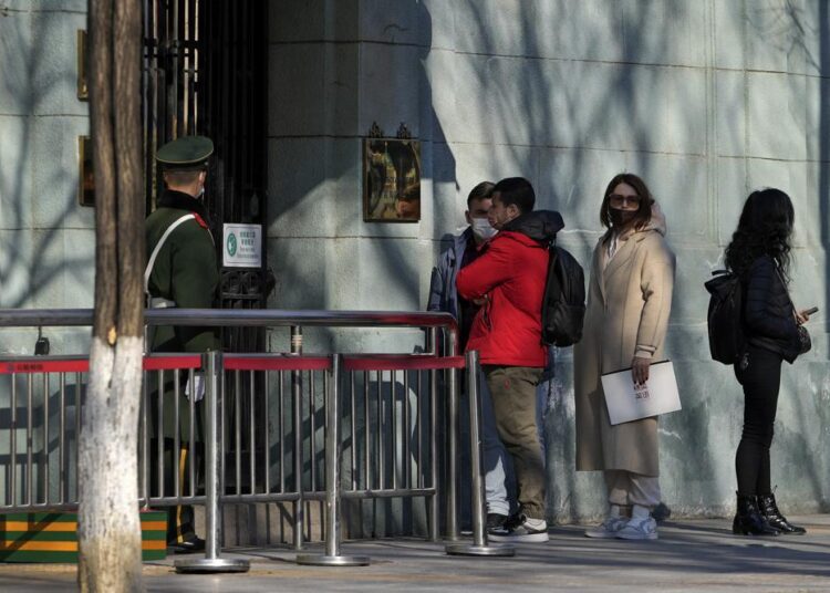 A Chinese paramilitary policeman stands watch as people wait to enter the Russian Embassy in Beijing, on Thursday, February 24, 2022.