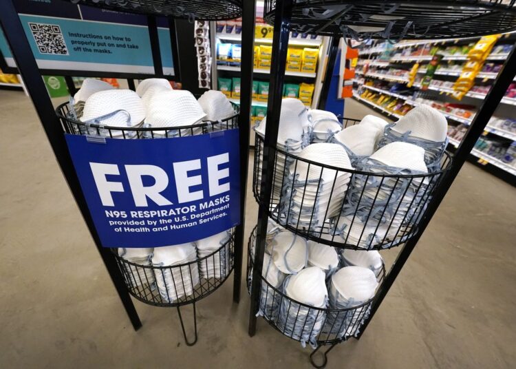 A product stall filled with free N95 respirator masks, provided by the US Department of Health and Human Services, sits outside the pharmacy at this Jackson, Miss., Kroger grocery store on Feb. 2, 2022.