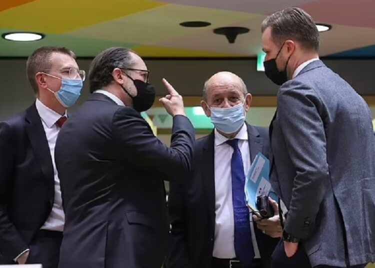 French Foreign Minister Jean-Yves Le Drian, second right, speaks with Austria's Foreign Minister Alexander Schallenberg, second left, during a meeting of EU foreign ministers in Brussels, on Feb. 25, 2022.