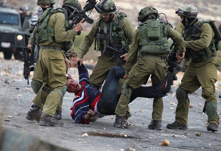 Israeli soldiers detain a wounded Palestinian stone thrower after infiltrated members of the Israeli security forces shot at fellow protesters during clashes in Beit El, on the outskirts of the West Bank city of Ramallah, on October 7, 2015. New violence rocked Israel and the Israeli-occupied West Bank, including a stabbing in annexed east Jerusalem, even as Israel and Palestinian president Mahmud Abbas took steps to ease tensions. AFP PHOTO / ABBAS MOMANI