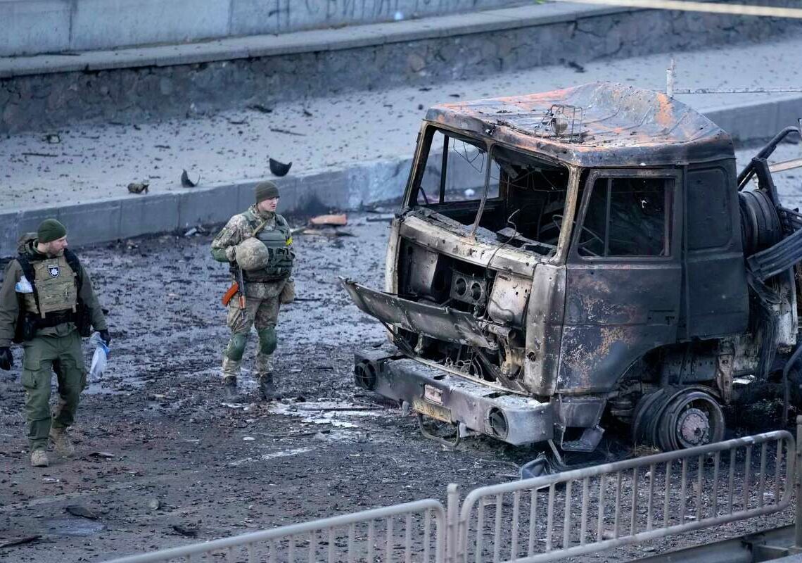 Ukrainian troops inspect the site following a Russian airstrike in Kyiv, Ukraine, Saturday, Feb. 26, 2022.