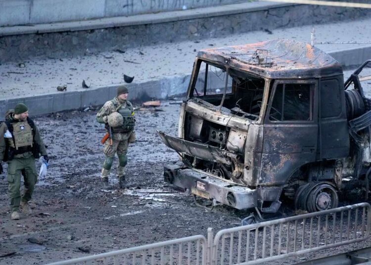 Ukrainian troops inspect the site following a Russian airstrike in Kyiv, Ukraine, Saturday, Feb. 26, 2022.