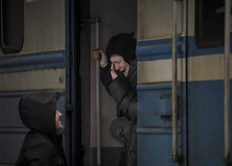 A woman on a Lviv bound train cries while she bids goodbye to a man in Kyiv, Ukraine, Saturday, March 12, 2022. Fighting raged in the outskirts of Ukraine's capital, Kyiv, and Russia kept up its bombardment of other resisting cities.