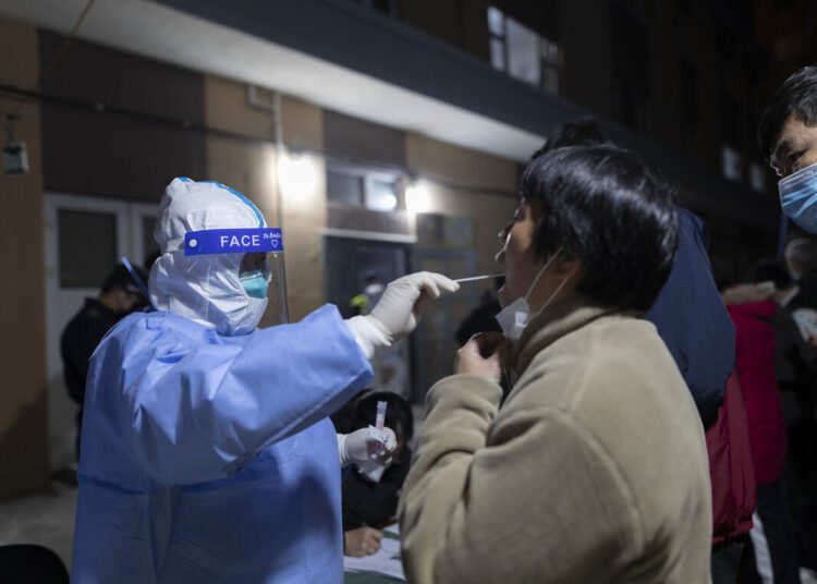 A file photo shows a woman gets her throat swabbed in Shanghai as part of China’s ‘zero tolerance’ strategy.
