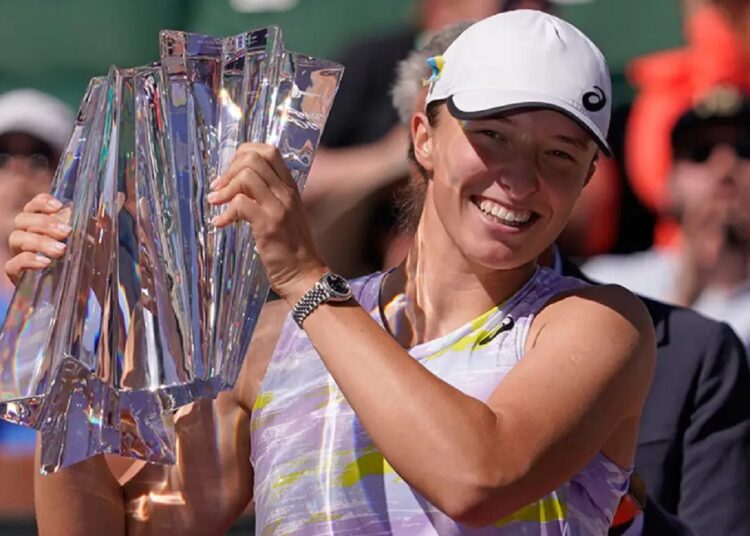 Iga Swiatek poses with the Indian Wells trophy.