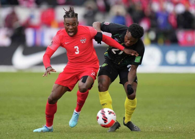 Canada's Sam Adekugbe (L) and Jamaica's Javain Brown battle for the ball during their CONCACAF World Cup qualifying match in Toronto.