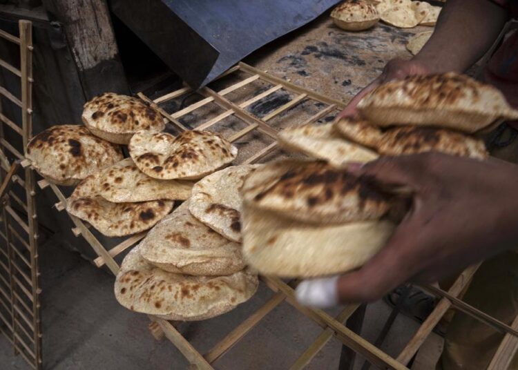 A worker collects Egyptian traditional 'baladi' flatbread, at a bakery, in el-Sharabia, Shubra district, Cairo, Egypt, Wednesday, March 2, 2022. The Russian tanks and missiles besieging Ukraine also are threatening the food supply and livelihoods of people in Europe, Africa and Asia who rely on the vast, fertile farmlands of the Black Sea region. That could create food insecurity and throw more people into poverty in places like Egypt and Lebanon, where diets are dominated by government-subsidized bread.