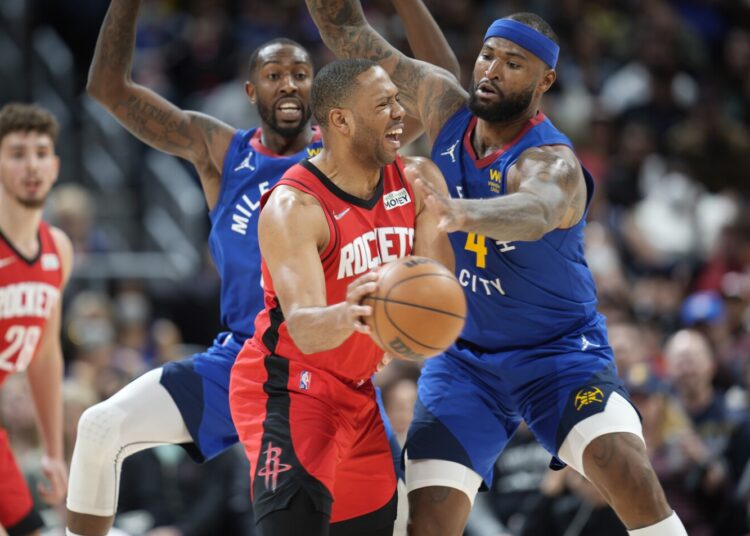 Houston Rockets guard Eric Gordon (C) passes the ball under pressure from Denver Nuggets guard Davon Reed (L) and center DeMarcus Cousins during their NBA game in Denver. The Nuggets won 116-101.