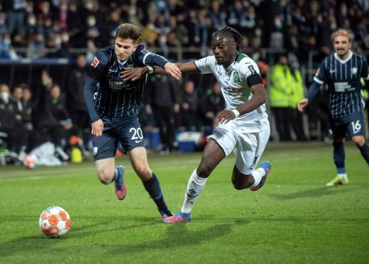 Bochum's Elvis Rexhbecaj and Monchengladbach's Kouadio Kone, right, battle for the ball during their Bundesliga match in Bochum, Germany.