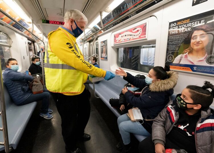 US extends mask rule for travel while weighing new approach 1 - Egyptian Gazette A file photo shows Patrick Foye, Chairman and CEO of the Metropolitan Transportation Authority, hands out face masks on a New York City subway, on Nov. 17, 2020.
