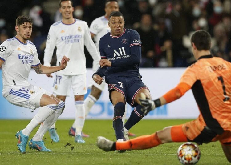 PSG's Kylian Mbappe scores past Real Madrid's goalkeeper Thibaut Courtois in the first-leg of their UEFA Champions League round of 16 on Feb. 15, 2022.