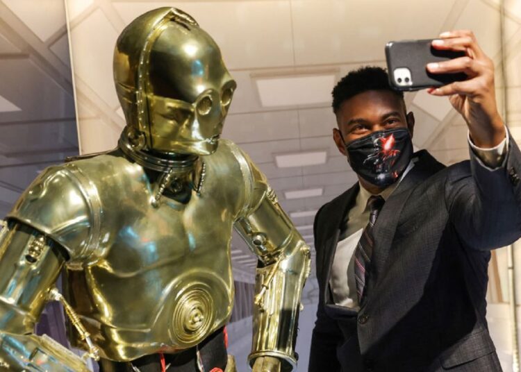 New York exhibition showcases over 600 'Star Wars' collectable items 1 - Egyptian Gazette A person takes a selfie with a life-size figure of C-3PO at "The Fans Strike Back: The Largest Star Wars Fan Exhibition" in Manhattan, New York City, US, March 24, 2022.
