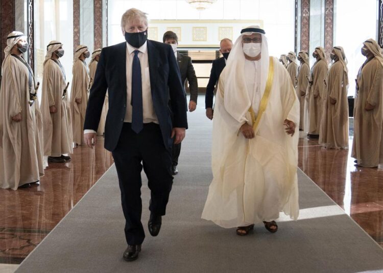British Prime Minister Boris Johnson, left, inspects the honour guard as he arrives at Abu Dhabi airport for his visit to the United Arab Emirates, on Wednesday, March 16, 2022.