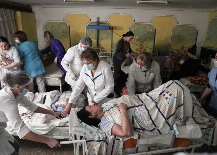 Medical workers move a patient in a basement of a maternity hospital converted into a medical ward and used as a bomb shelter in Mariupol, Ukraine, on Tuesday, March 1, 2022.