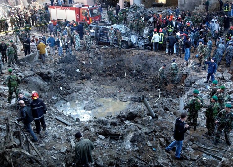 A file photo shows rescue workers and soldiers stand around a massive crater after a bomb attack that tore through the motorcade of former Prime Minister Rafik Hariri in Beirut, Lebanon, Feb. 14, 2005.