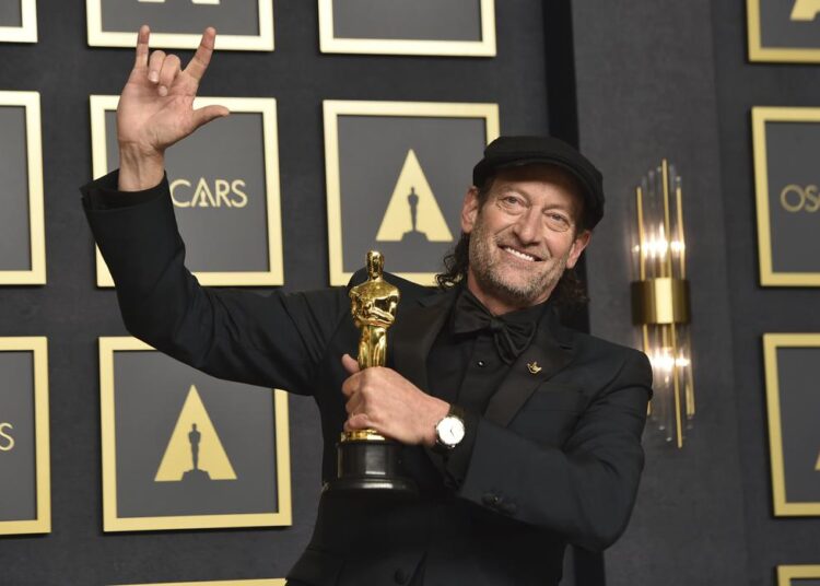 Troy Kotsur, winner of the award for best performance by an actor in a supporting role for "CODA," poses in the press room at the Oscars on Sunday, March 27, 2022, at the Dolby Theatre in Los Angeles.