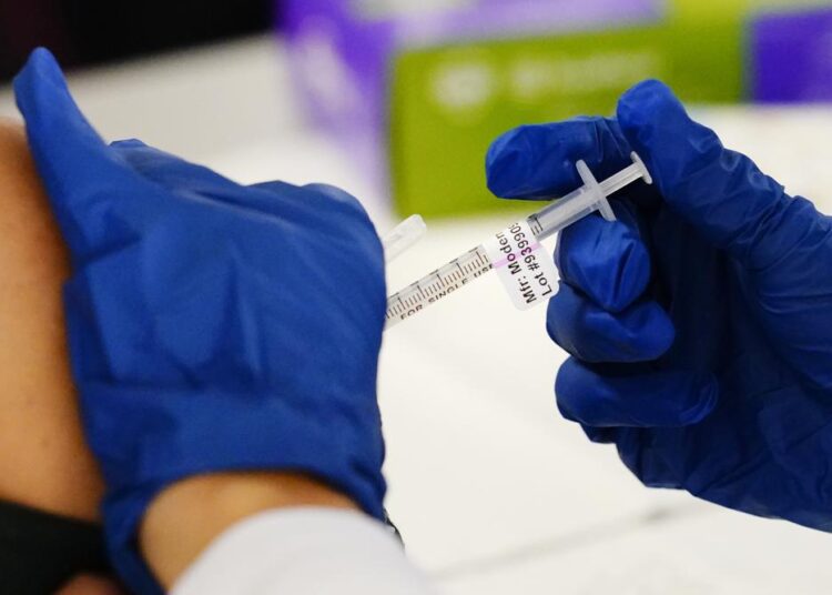 FILE - A health worker administers a dose of a Moderna COVID-19 vaccine during a vaccination clinic at the Norristown Public Health Center in Norristown, Pa., Tuesday, Dec. 7, 2021. Moderna says its COVID-19 vaccine works in babies, toddlers and preschoolers. The company announced early findings from a study of children younger than 6 on Wednesday, March 23, 2022.