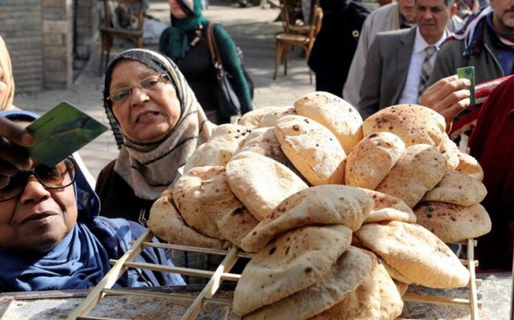 A file photo shows an Egyptian women buys government subsidised bread from a bakery in Cairo.