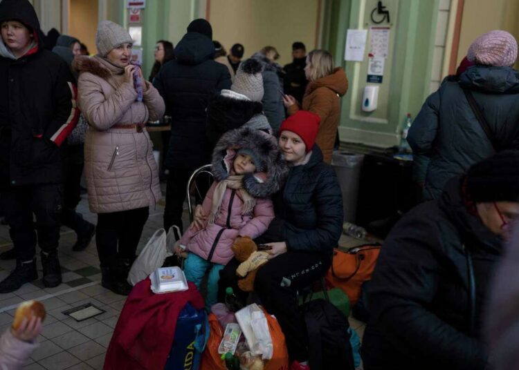 Ukrainian refugees wait at Przemysl train station, southeastern Poland, on Friday, March 11, 2022.