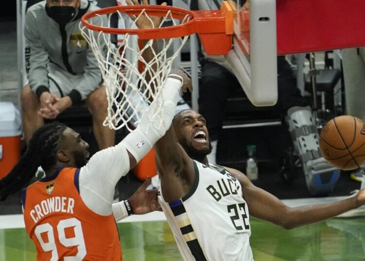 Milwaukee Bucks Khris Middleton (R) drives around Phoenix Suns Jae Crowder during their NBA Finals in Milwaukee.